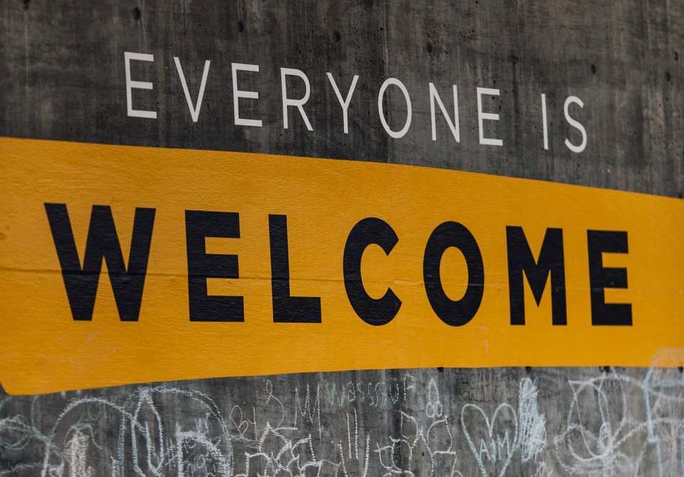 A signage that says everyone is welcome as a way of saying the event is accessible