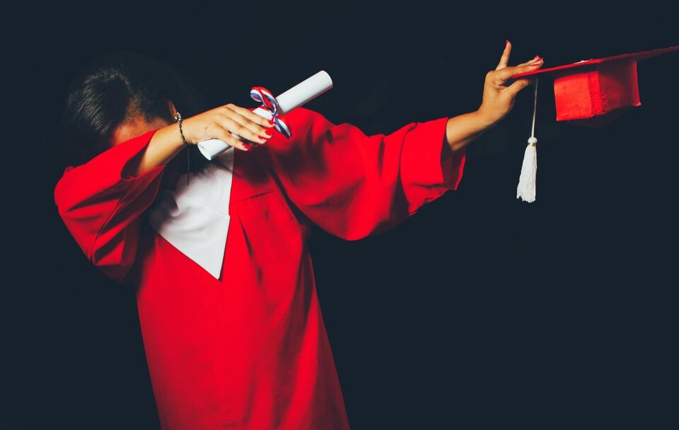 A person in a red graduation dress to symbolize event planners being certified