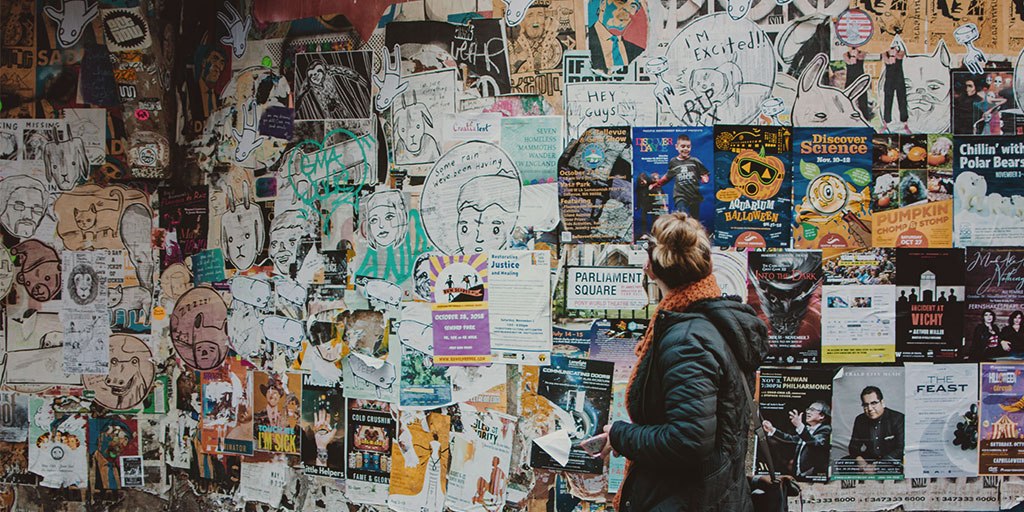 Woman looking at wall posters in the street