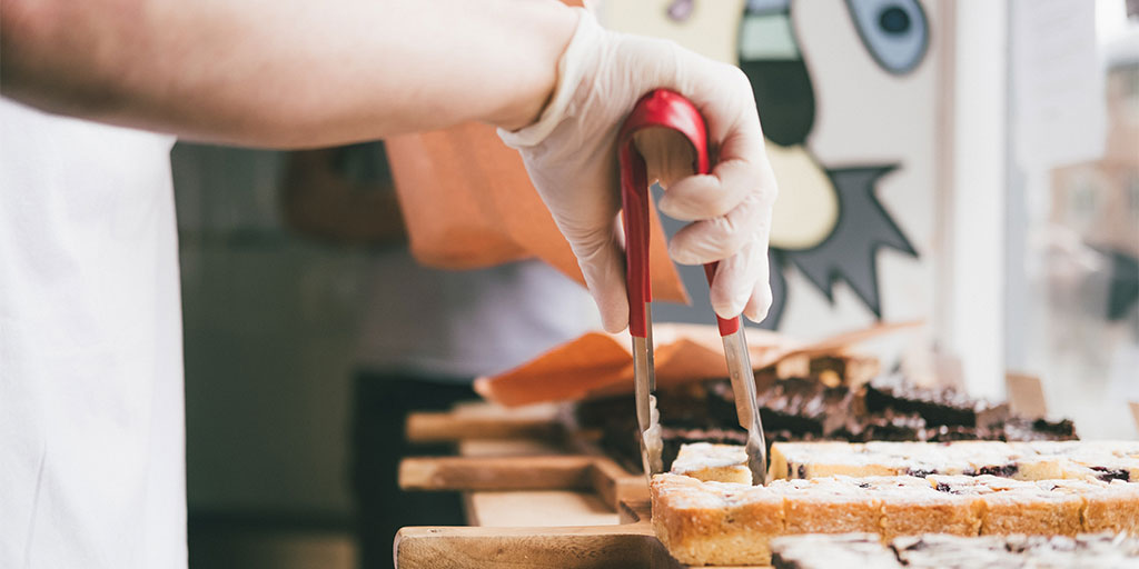 A baker handing out slices of cake