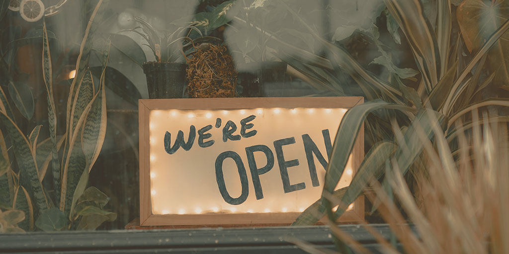 A shop sign that reads, "we're open"