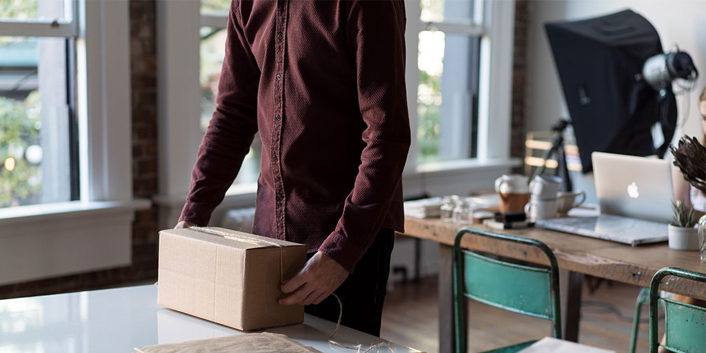 image of a person tying a rope around a brown package