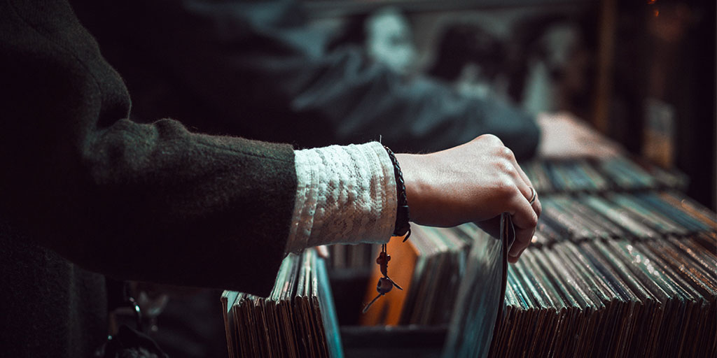 image of a woman's hand flipping through comic books in a shelf