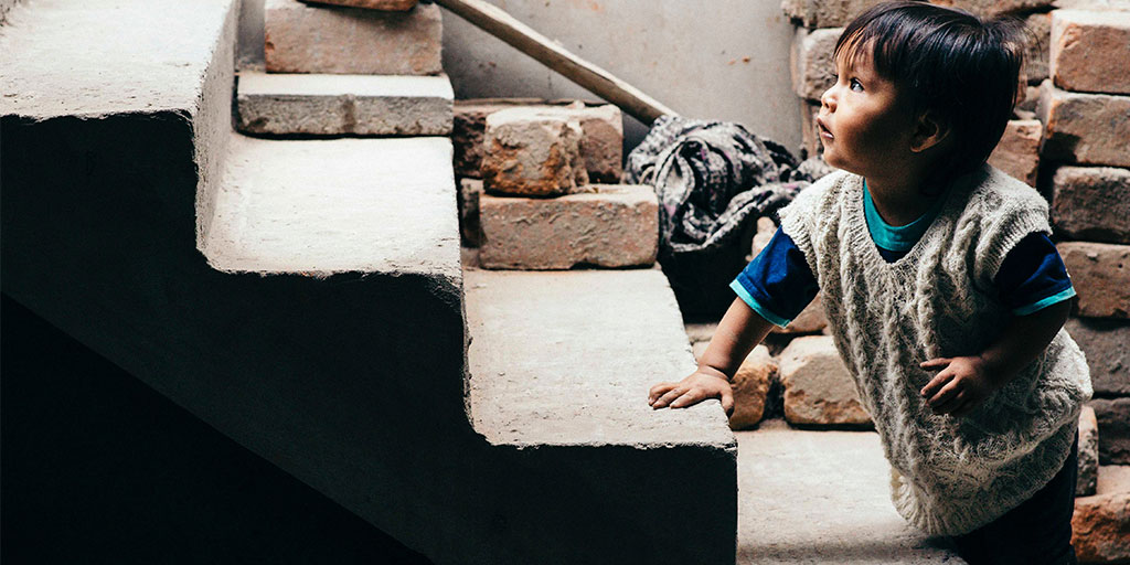 image of a toddler on a stair, looking up the staircase