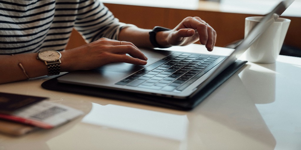 A person's hand working on a laptop