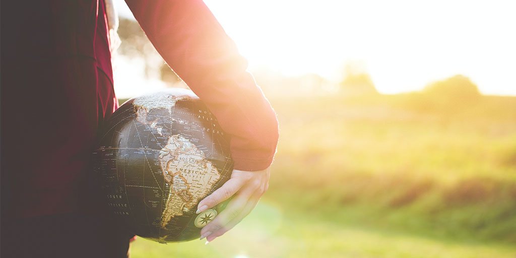 "child holding a globe in a playing field"